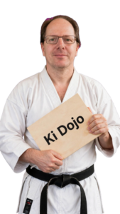 Mann hält Karate Holzbrett mit Aufschrift Ki Dojo